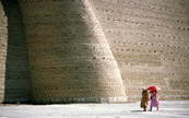 Femme marchant devant un grand mur